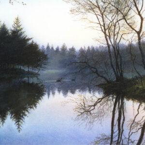 This is a signed limited edition print from an original soft pastel painting by artist Michael Howley. A tranquil scene across the lake in the early morning with the low glow of the sun breaking through bare trees on the right. There is an island of fir trees to the left which is reflected in still blue water. Landscape colours are soft blue-greens, dark green fir trees, blue reflections and yellow, orange and red hues in the sunlight glow.