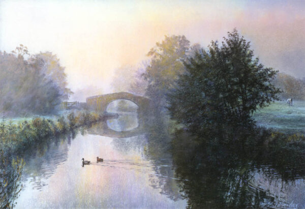 This is a signed limited edition print of an original soft pastel painting by artist Michael Howley. The subject of the painting is a tranquil misty morning scene of the canal with a bridge which is surrounded by trees which soften into the distant mist. Colours in the atmospheric sky are creamy whites, pale pinks, peaches, blues and purples which are reflected in the calm waters. Two ducks float serenely across the surface.